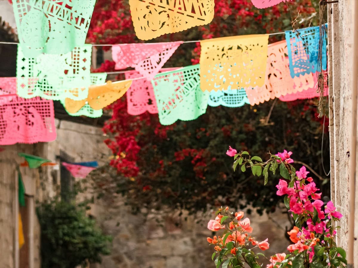 Callejón decorado con papel picado y buganvilia